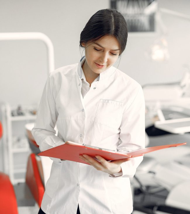 Woman in a uniform. Doctor working at the clinic. Dentist holds a folder in her hands